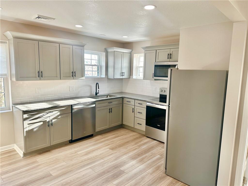 197 West Main Street, Unit 2 Uniontown, PA 15401 - Photo 6 of 13 a kitchen with a sink white cabinets and stainless steel appliances
