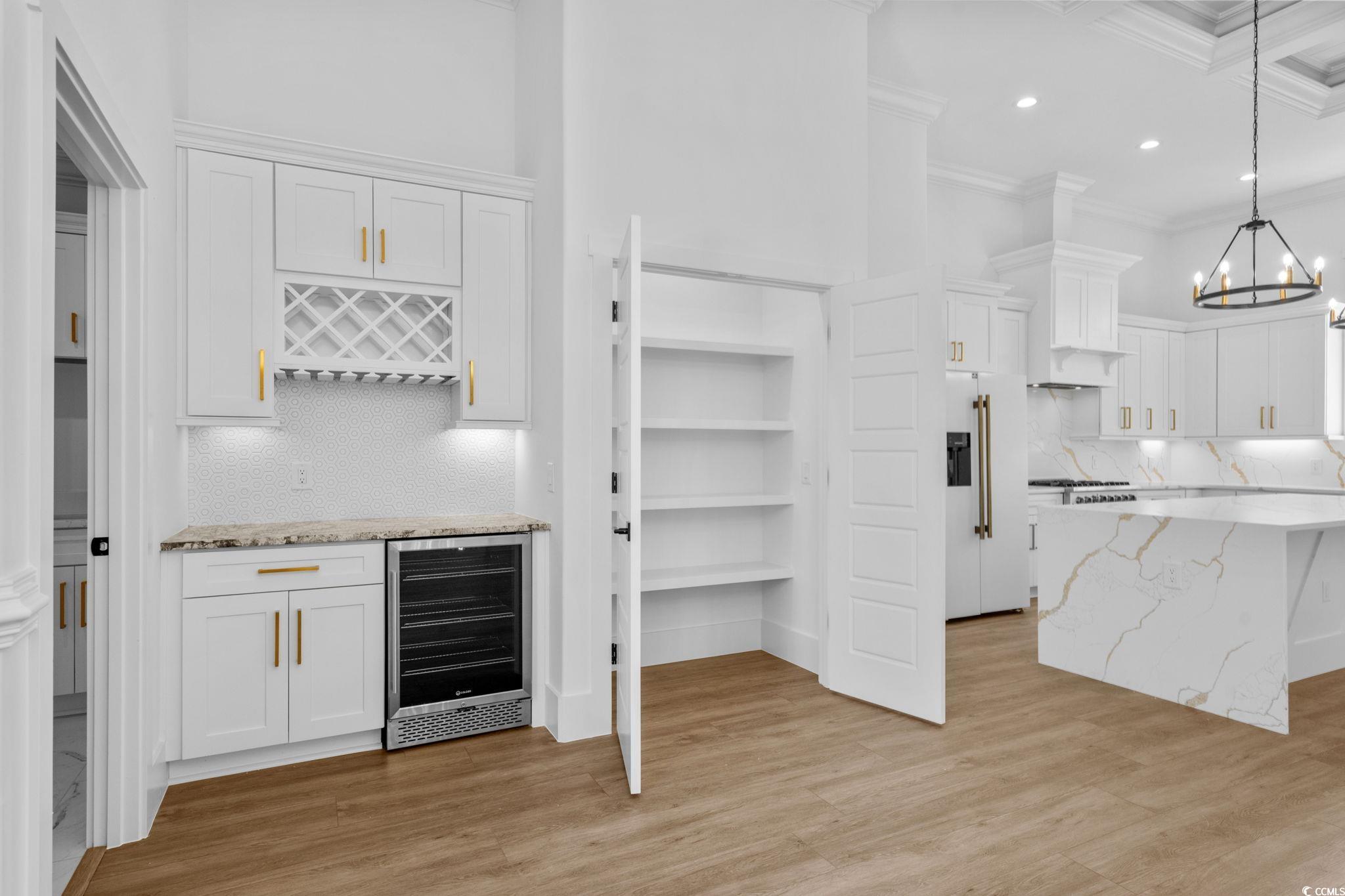 562 Linton Park Road Myrtle Beach, SC 29579 - Photo 17 of 40 Kitchen with backsplash, white cabinetry, light stone counters, recessed lighting, and a towering ceiling
