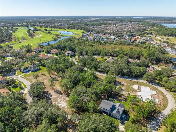 an aerial view of a houses with a yard and lake view