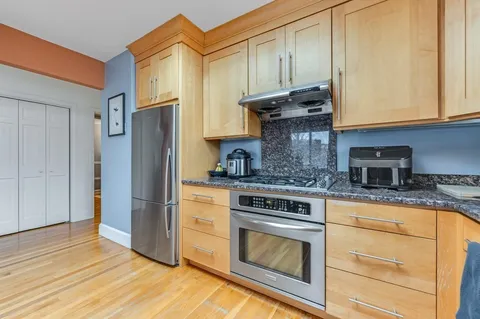 a kitchen with granite countertop wooden cabinets stainless steel appliances and a counter space