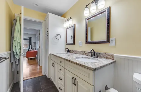 a en suite bathroom with a granite countertop sink and a mirror