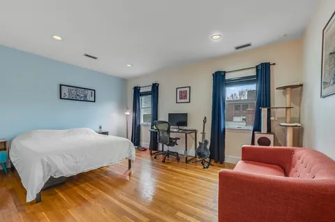 a bedroom with a bed and wooden floor