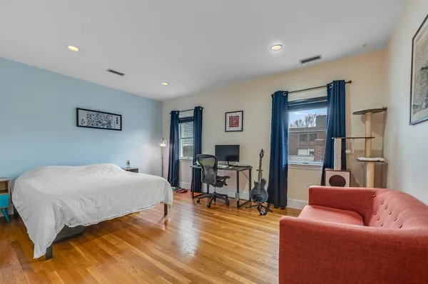 a bedroom with a bed and wooden floor