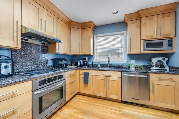 a kitchen with stainless steel appliances granite countertop a stove a sink and a microwave