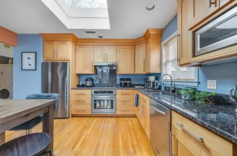 a kitchen with stainless steel appliances granite countertop a refrigerator a stove top oven a sink and dishwasher