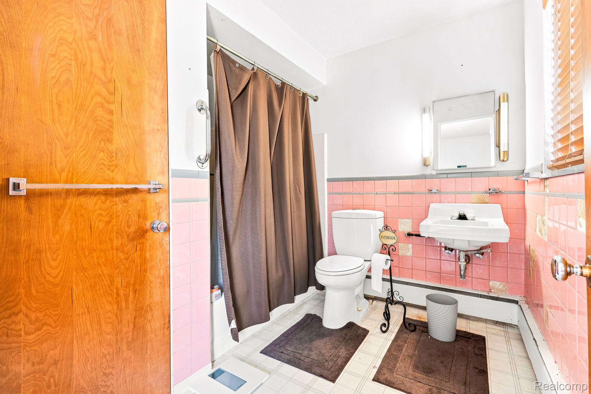 9735 Dolan Road Columbus, MI 48063 - Photo 31 of 63 Bathroom featuring a wall-mounted pedestal sink, white toilet, and pink tiled wainscoting