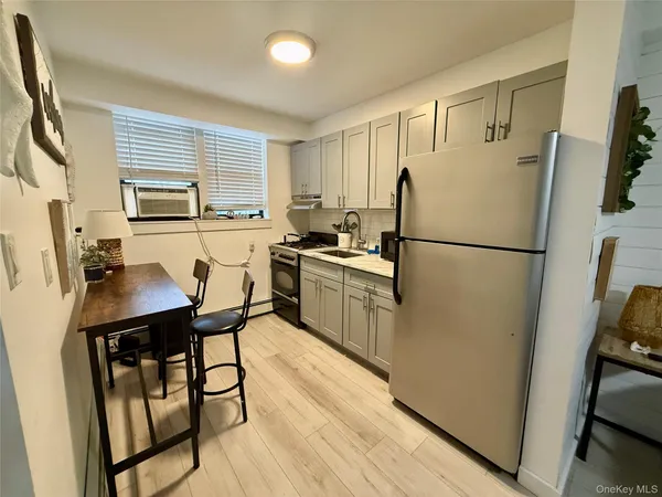 a kitchen with stainless steel appliances a refrigerator a sink a stove a table and chairs