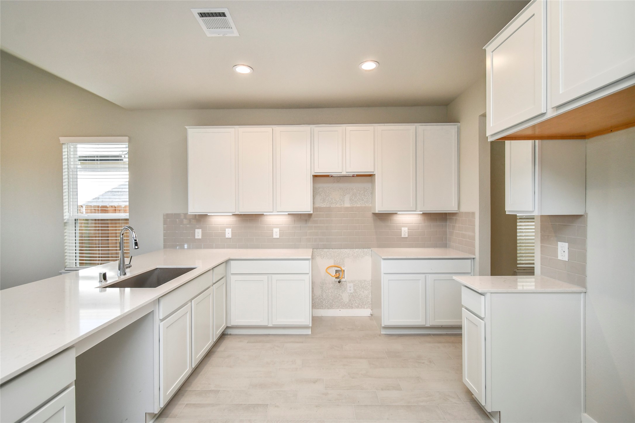 15203 Statice Trail Houston, TX 77044 - Photo 10 of 21 a kitchen with a sink white cabinets and white appliances