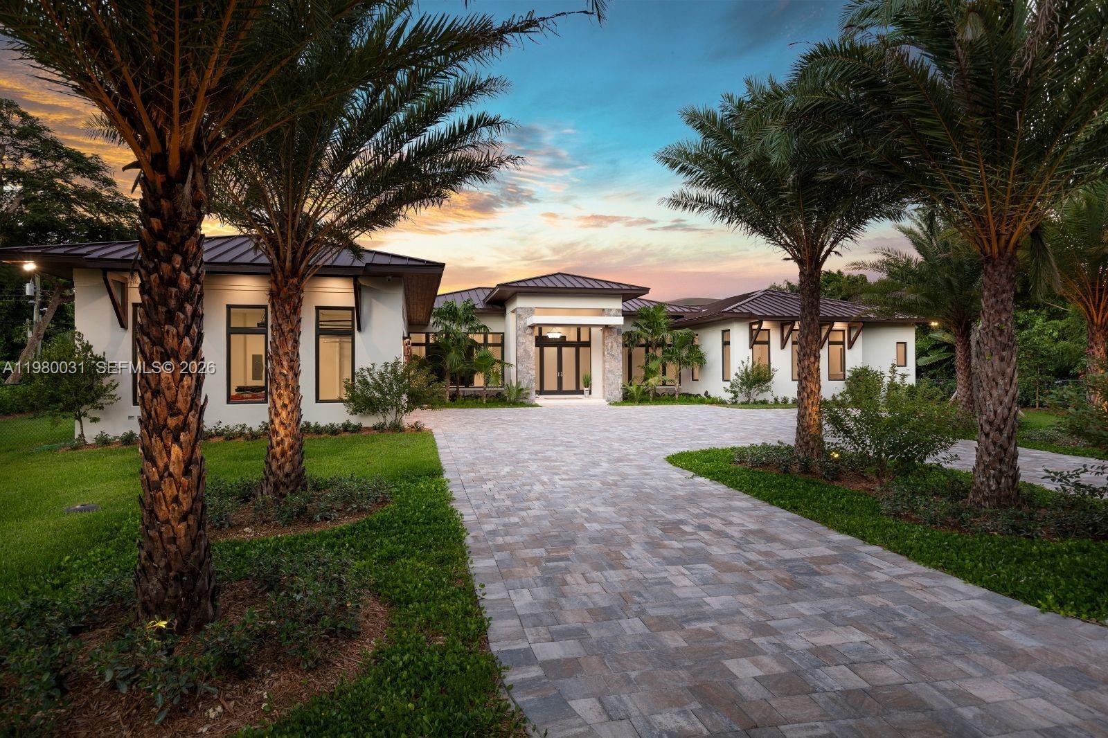 6065 Southwest 109th Street Pinecrest, FL 33156 - Photo 1 of 28 a front view of a house with a garden and trees