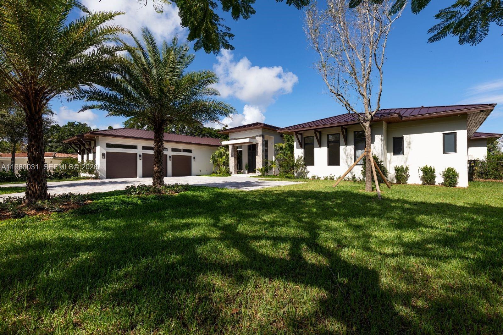 6065 Southwest 109th Street Pinecrest, FL 33156 - Photo 23 of 28 a front view of a house with a yard