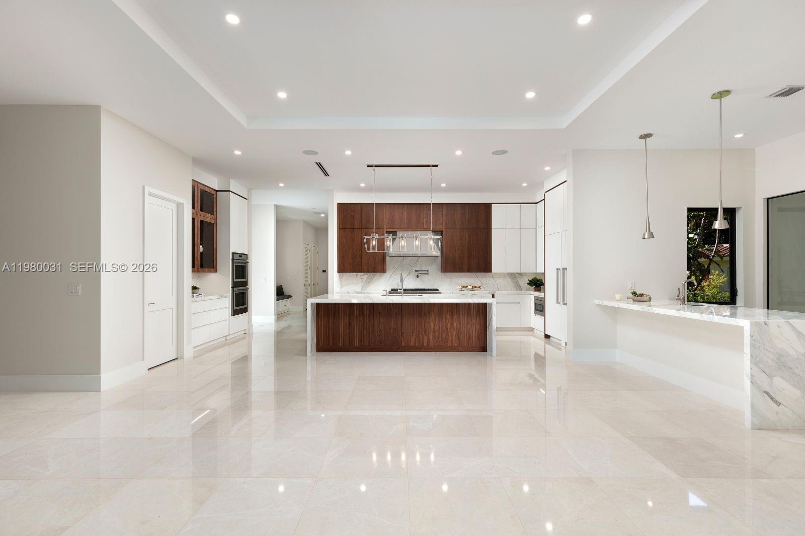6065 Southwest 109th Street Pinecrest, FL 33156 - Photo 9 of 28 a large white building with kitchen island a sink stainless steel appliances and cabinets