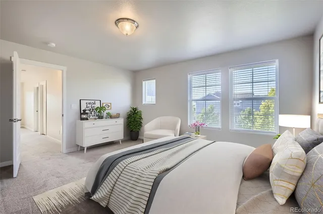 a bedroom with a bed a large window and couch