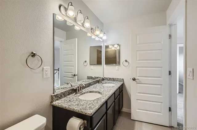 a bathroom with a granite countertop sink and a mirror
