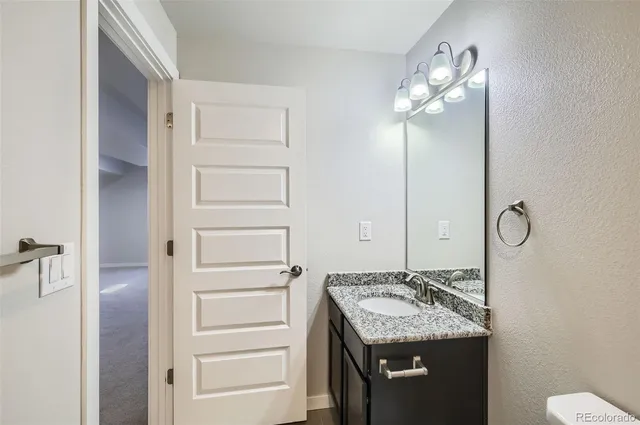 a bathroom with a granite countertop sink and a mirror