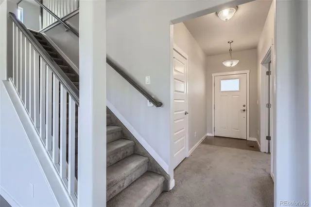 a view of a hallway with entryway and stairs
