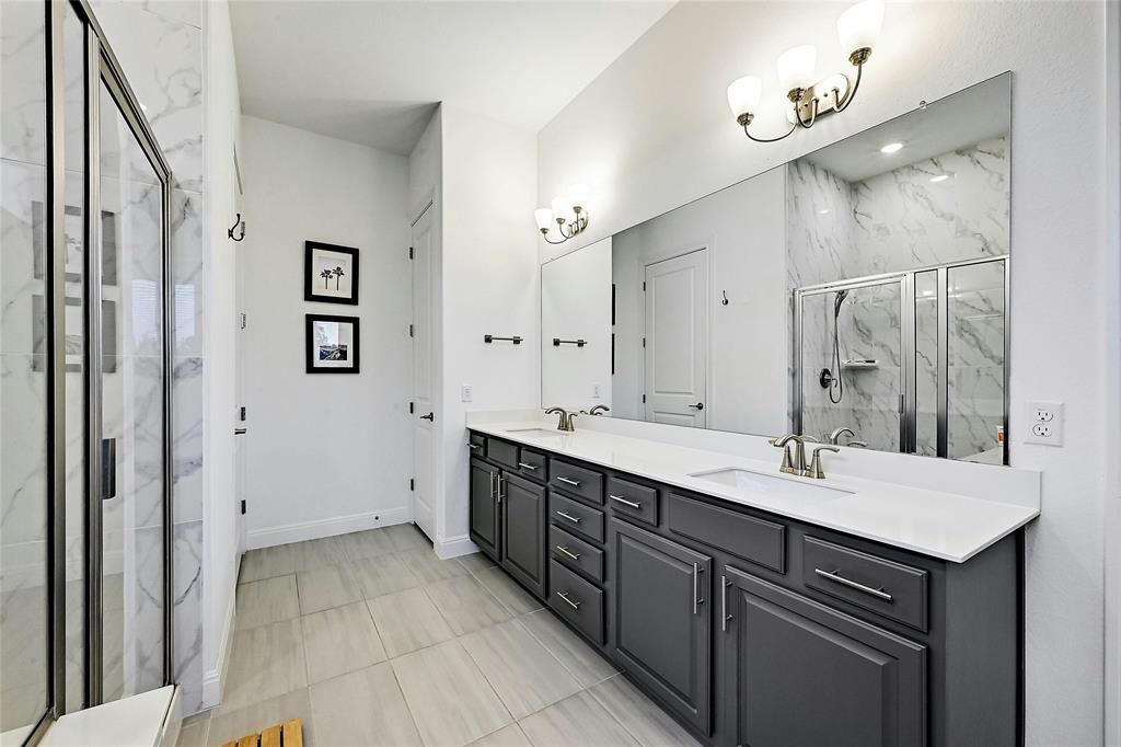 170 Climbing Rock Loop Dripping Springs, TX 78620 - Photo 15 of 30 Double vanity sinks and an enclosed shower with sophisticated tilework define this refreshing bathroom.
