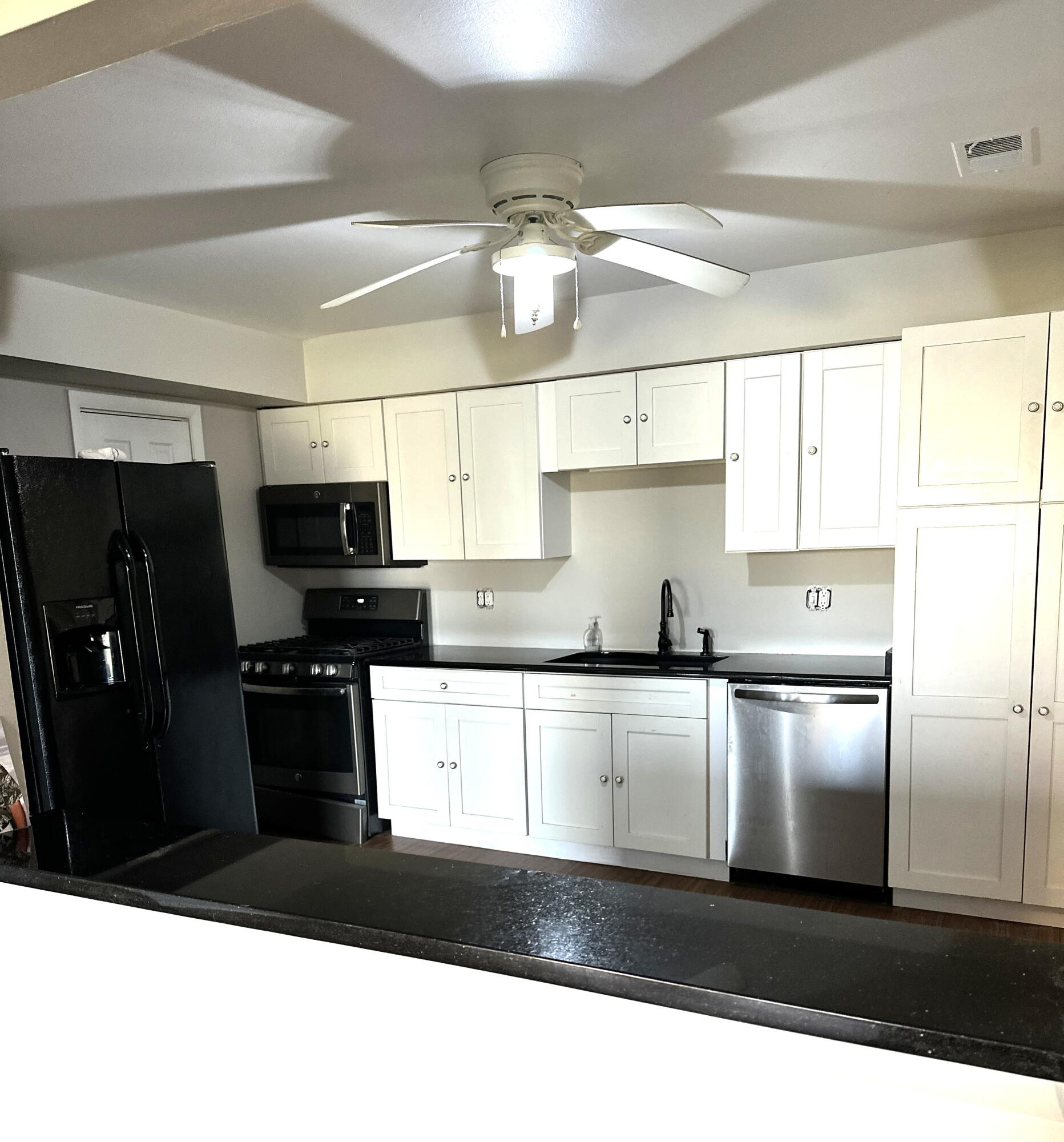 405 Old Stone Road, Unit E2 Munster, IN 46321 - Photo 7 of 20 a kitchen with a refrigerator a sink a stove a microwave and cabinets