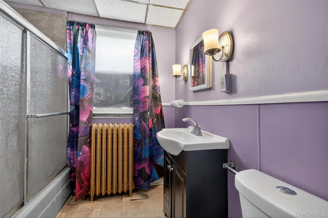 a bathroom with a sink vanity mirror and toilet