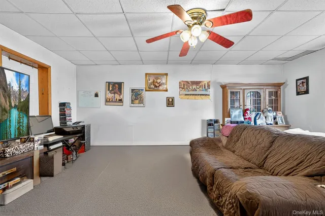 a living room with furniture a flat screen tv and a window