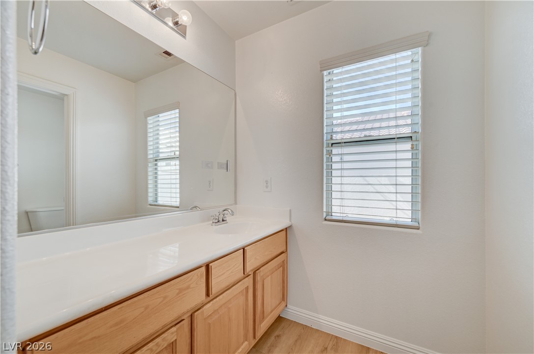 8918 Houston Ridge Avenue Las Vegas, NV 89178 - Photo 25 of 35 A bright bathroom with a light wood vanity, white countertop, and expansive mirror offers everyday convenience.