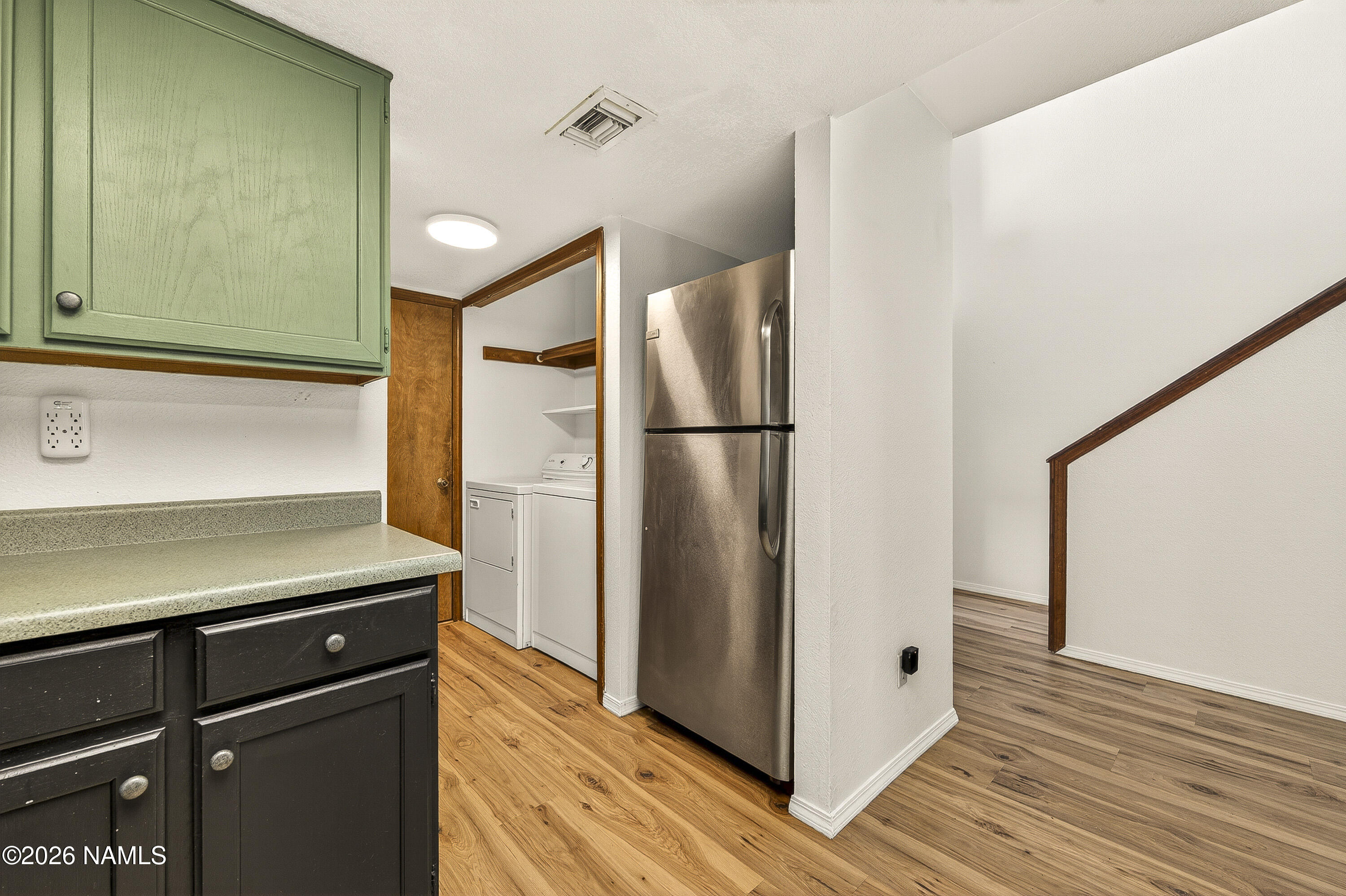 4005 South Lake Mary Road, Unit 9 Flagstaff, AZ 86005 - Photo 14 of 31 a view of a kitchen with wooden floor and a refrigerator