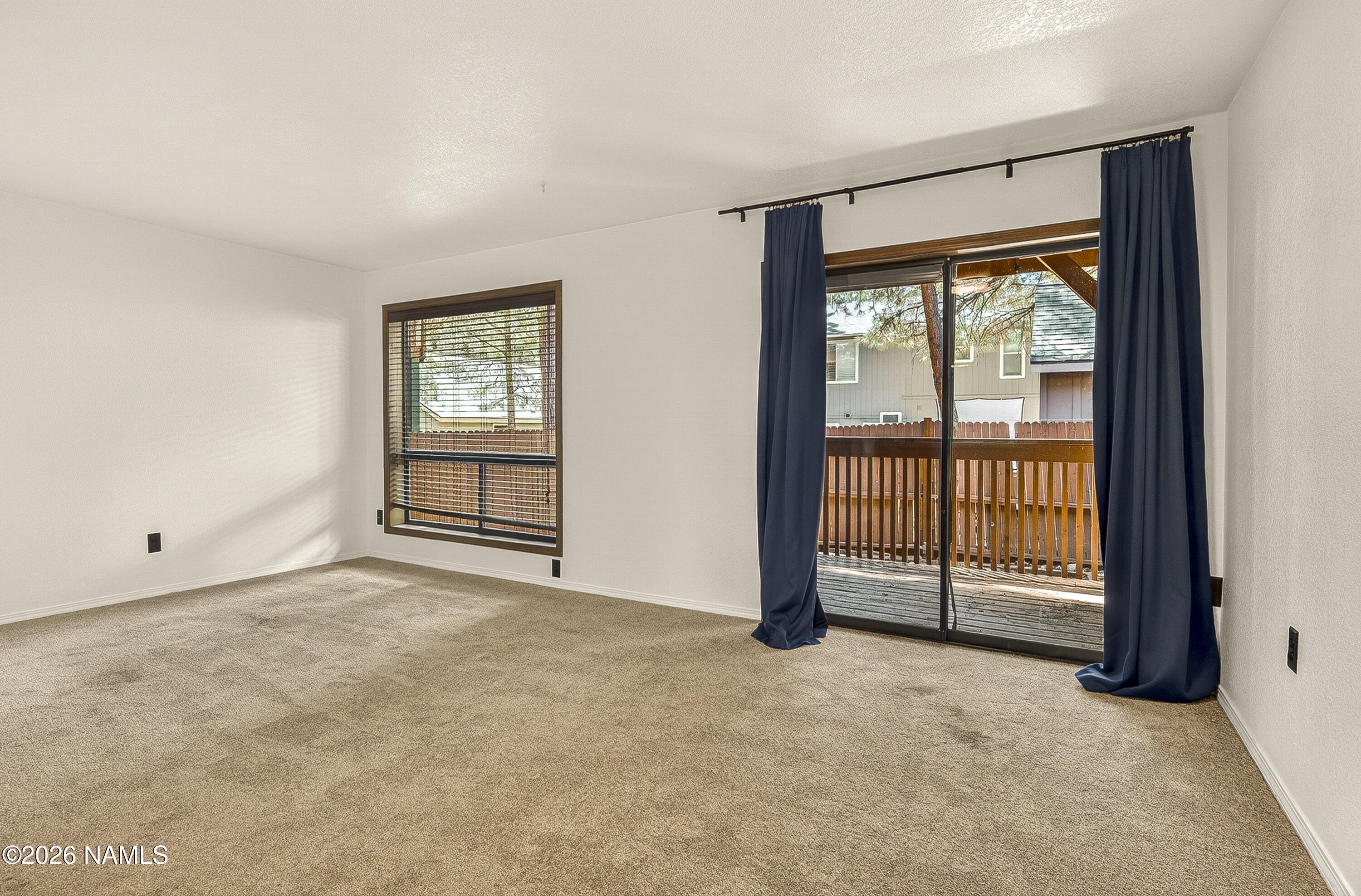 4005 South Lake Mary Road, Unit 9 Flagstaff, AZ 86005 - Photo 5 of 31 a view of an empty room with a fireplace and a window