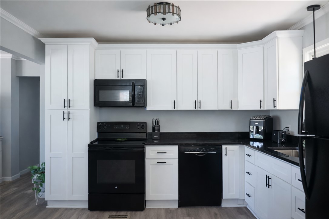 9432 Highway 81 Iva, SC 29655 - Photo 8 of 19 Bright and inviting kitchen features white cabinetry, sleek black appliances, and durable countertops.