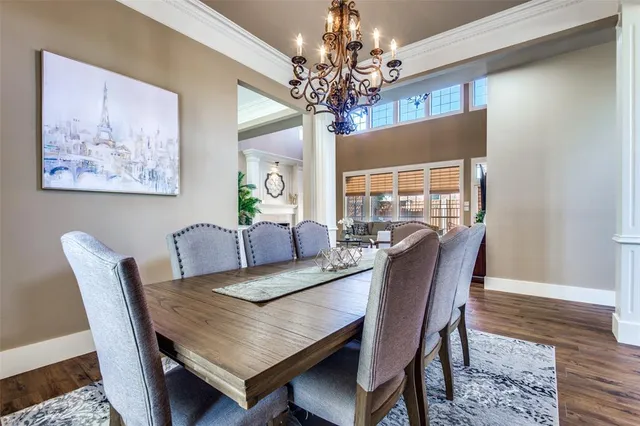 a view of a dining room with furniture a chandelier and wooden floor