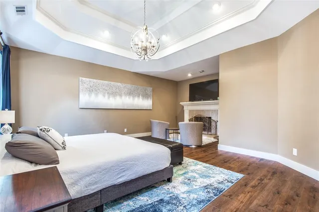 a bedroom with a bed wooden floor and a chandelier