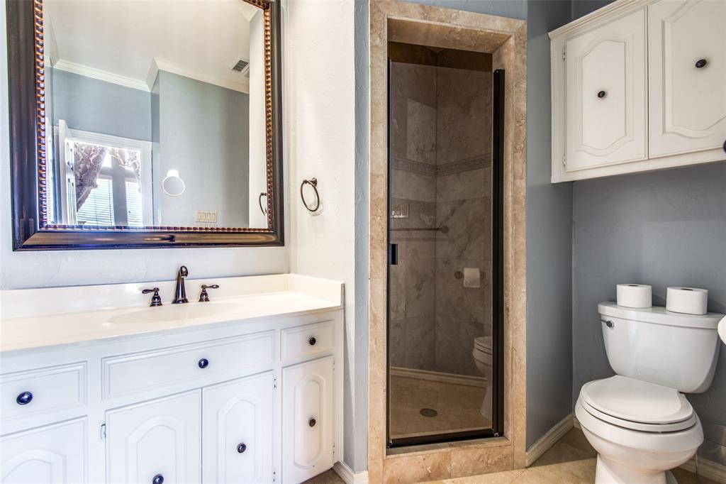 3400 Snidow Drive Plano, TX 75025 - Photo 22 of 25 a bathroom with a toilet sink vanity and shower