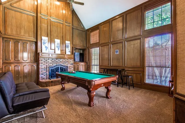 a living room with furniture a fireplace and large windows