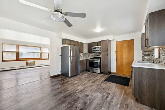 a kitchen with stainless steel appliances a refrigerator and wooden floor