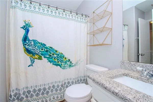a white toilet sitting next to a bathroom sink and a shower