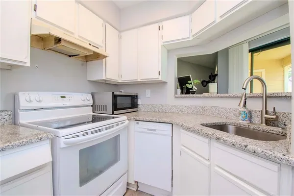 a kitchen with cabinets appliances and a sink