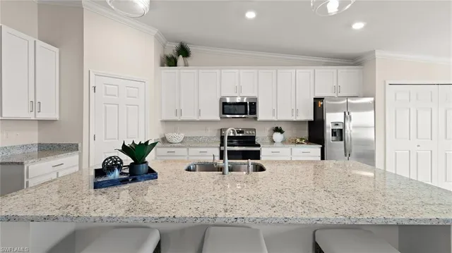 a kitchen with stainless steel appliances granite countertop a sink a stove and a counter space