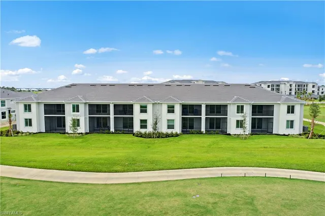 a view of a big house with a big yard and large trees