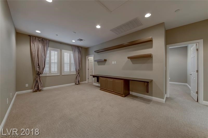 3144 Whitfeild Avenue Henderson, NV 89044 - Photo 15 of 55 A versatile bonus room offers carpeted comfort and built-in shelving, ready for personalization.