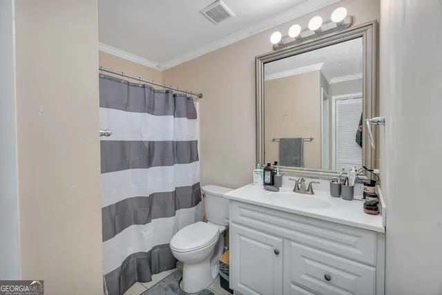 a bathroom with a sink a toilet a mirror and shower