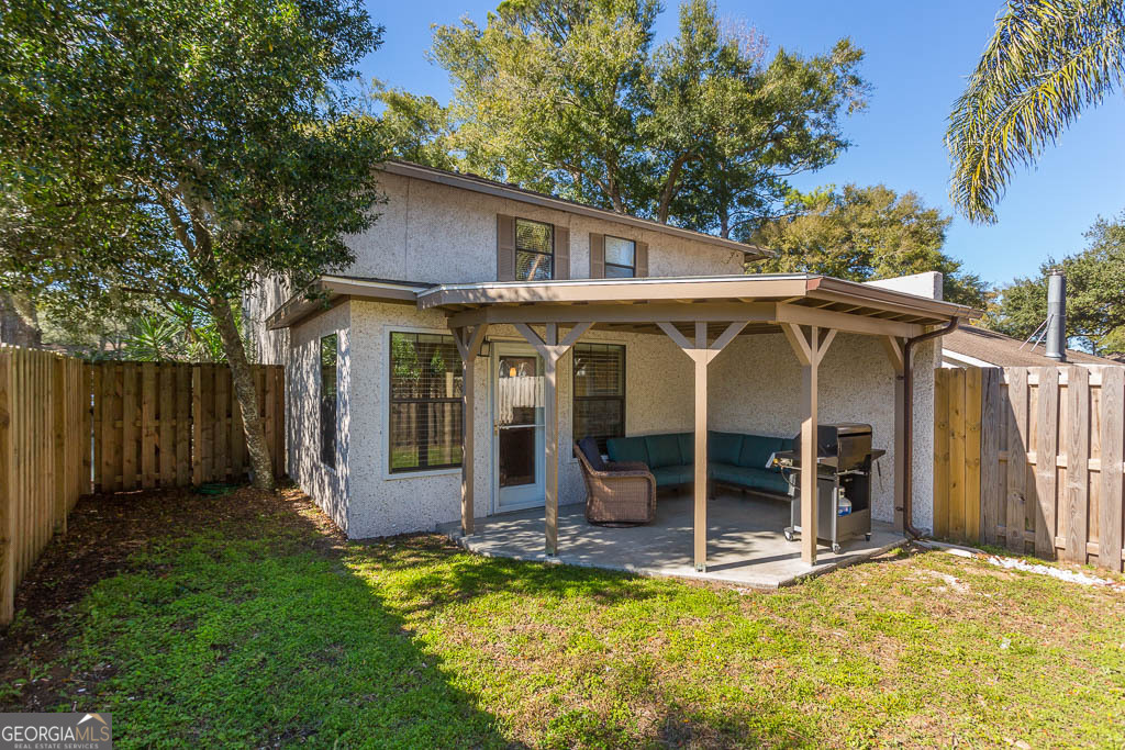 214 Island Drive St. Simons, GA 31522 - Photo 6 of 12 a view of a house with backyard porch and wooden fence