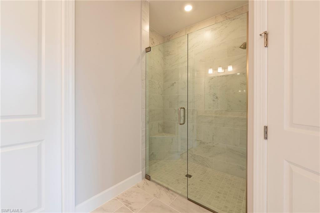 15633 Gavello Street Naples, FL 34114 - Photo 14 of 37 a bathroom with a glass shower door