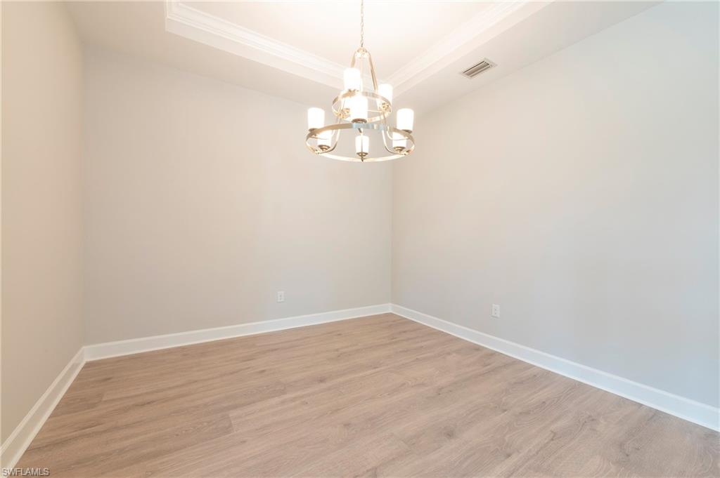 15633 Gavello Street Naples, FL 34114 - Photo 15 of 37 a view of a chandelier fan and hardwood floor