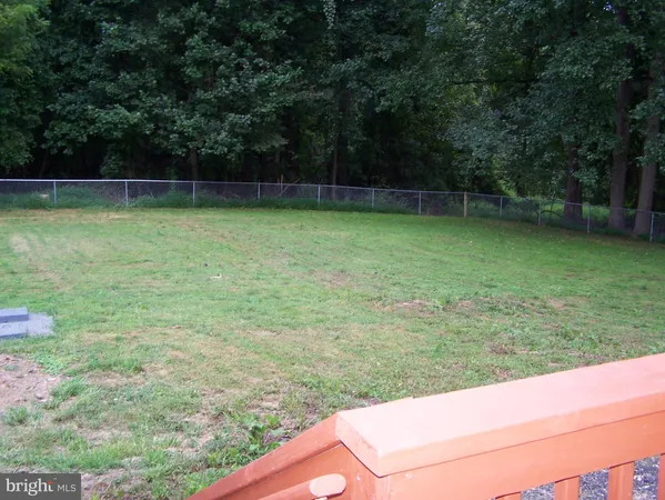 a view of a yard with a wooden fence