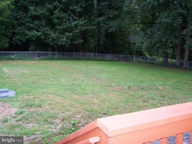 a view of a yard with a wooden fence
