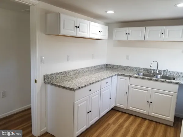 a kitchen with granite countertop white cabinets and a sink
