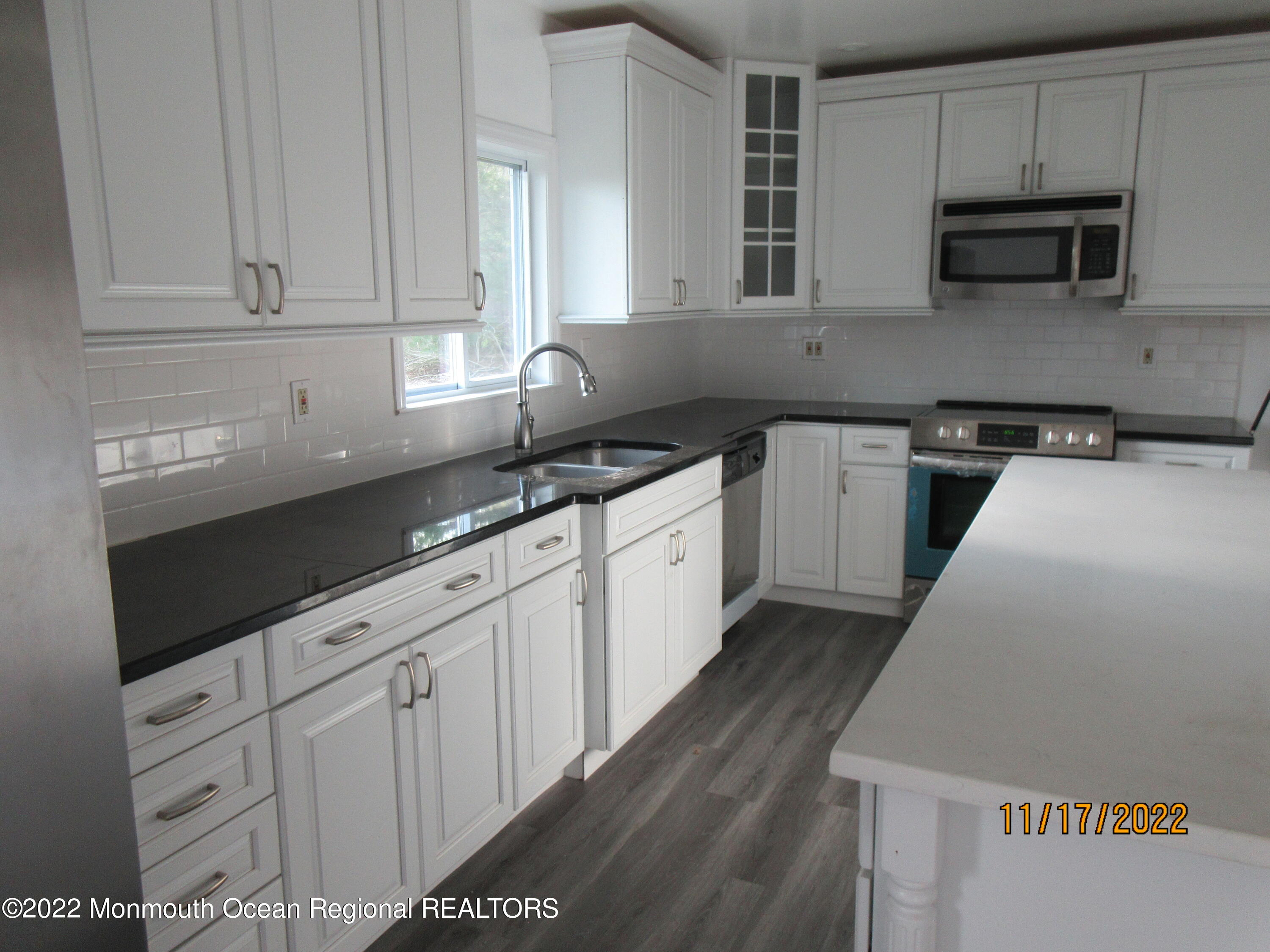 28 New Friendship Road Howell, NJ 07731 - Photo 4 of 29 a kitchen with granite countertop white cabinets and stainless steel appliances