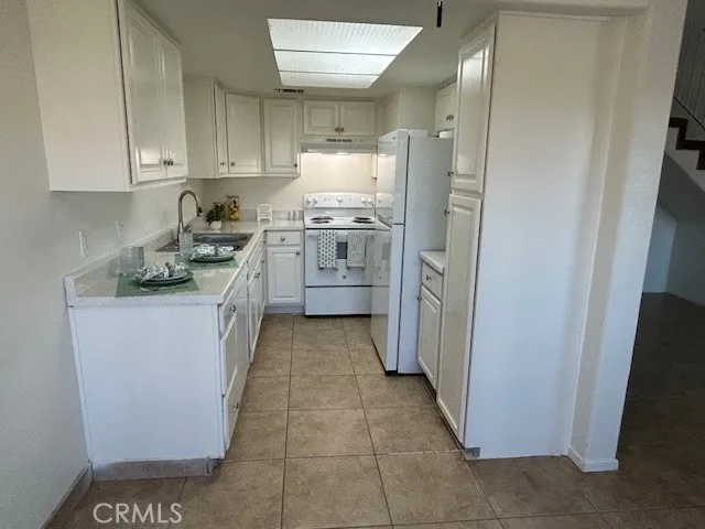 a kitchen with cabinets appliances a sink and a counter top space