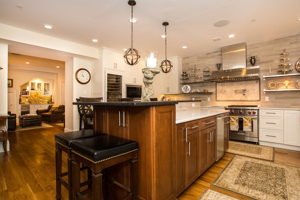 1 Winter Place, Unit 2 Boston, MA 02108 - Photo 2 of 17 a kitchen with stainless steel appliances granite countertop a stove a sink and a wooden floors