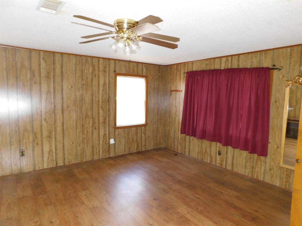 214 Springhill Airport Road Springhill, LA 71075 - Photo 17 of 32 an empty room with windows chandelier fan and windows