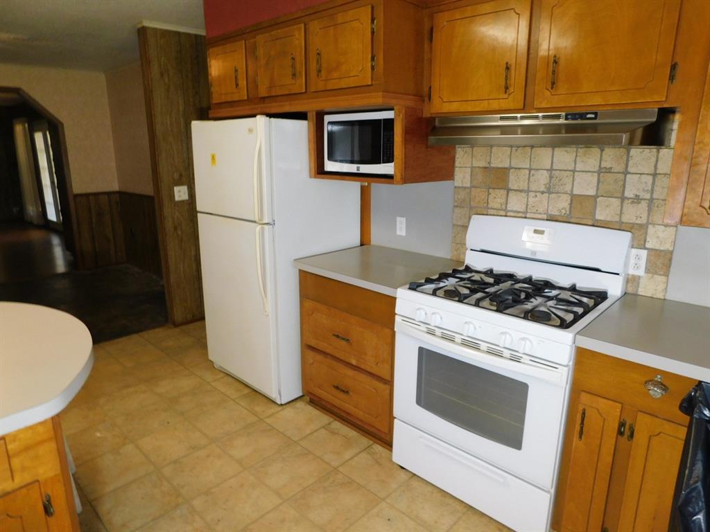 214 Springhill Airport Road Springhill, LA 71075 - Photo 25 of 32 a kitchen with a stove and a refrigerator