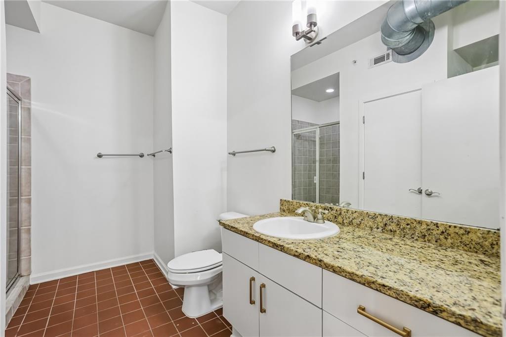 5300 Peachtree Road, Unit 3506 Atlanta, GA 30341 - Photo 19 of 25 a bathroom with a granite countertop sink a toilet and a mirror
